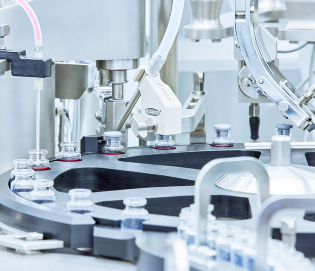 Machinery filling vials.
