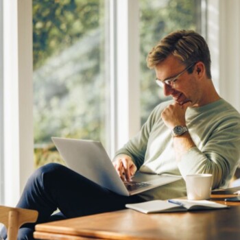 A man looking at a laptop on his lap