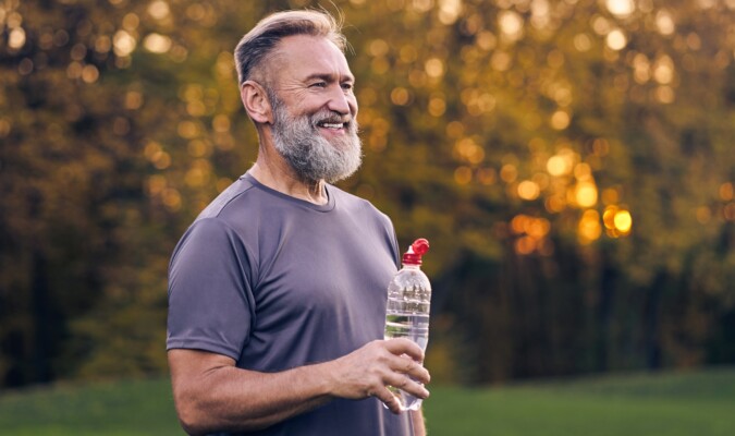 A man holding a water bottle while outside
