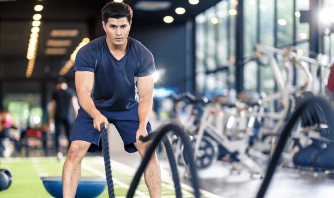A man working out by throwing ropes.