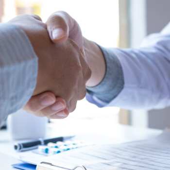 two people shaking hands to represent intersection of employers and healthcare providers
