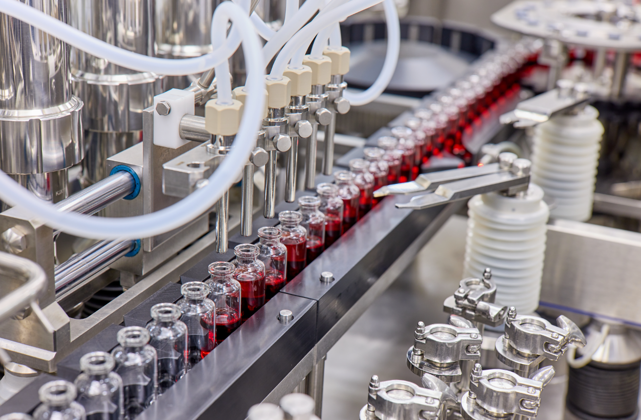A machine that's filling vials with a red liquid.