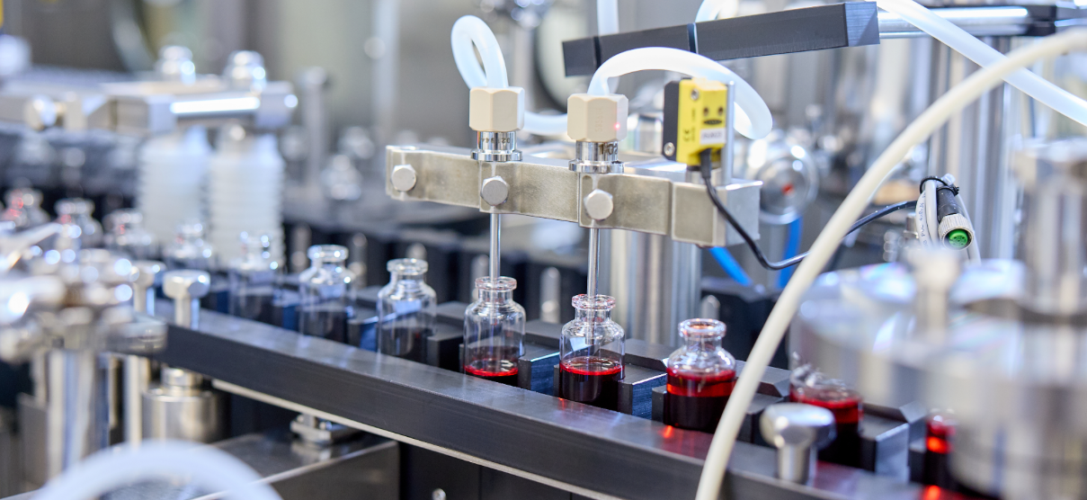 A machine filling vials with liquid.