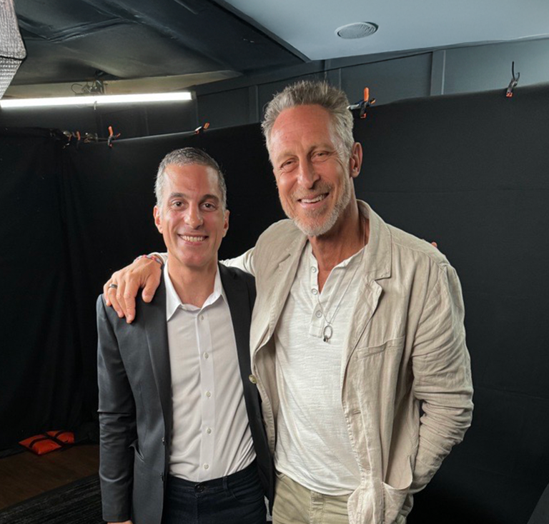 Two men, one in fancy attire the other in more casual clothes