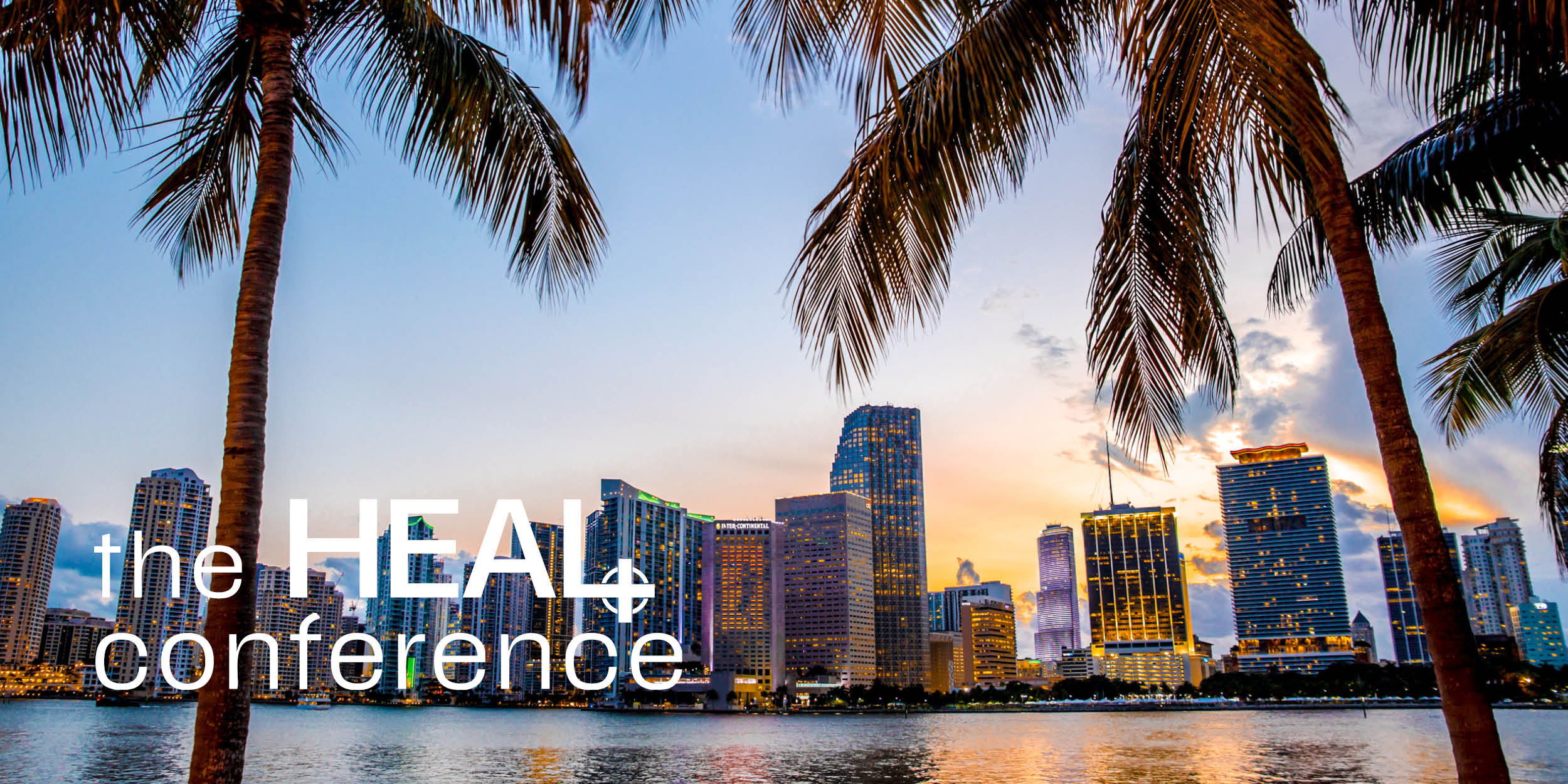 A city framed by palm trees with text "The HEAL conference"