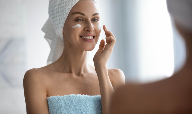 woman applying cream in the bathroom