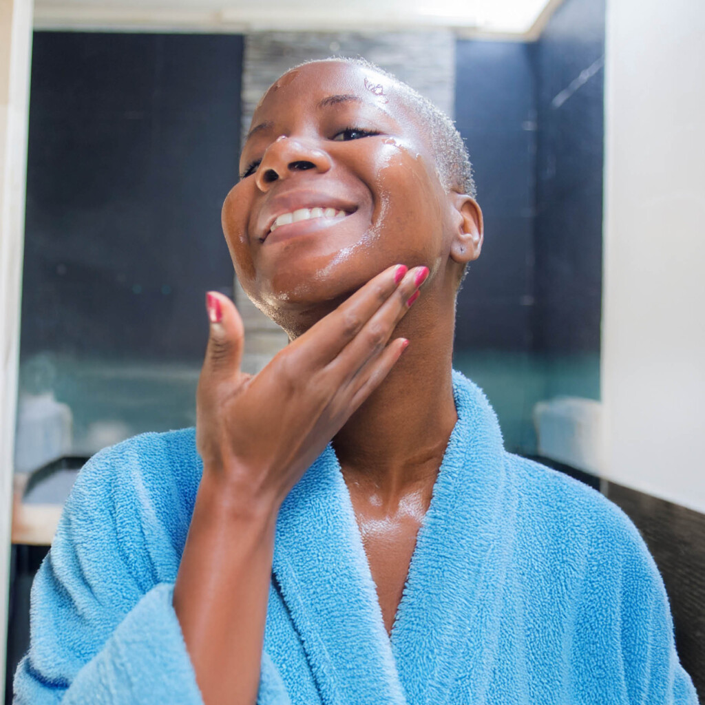 female in bathroom putting cream on