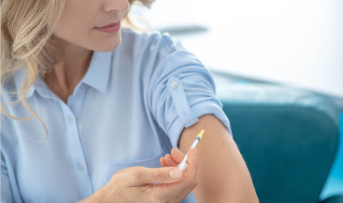 woman injecting medication in arm